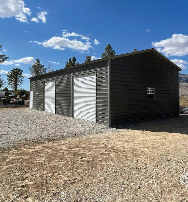 Insulated, two-car 24x30x10 custom metal garages with vertical roof panels and two roll-up doors for home vehicle storage.
